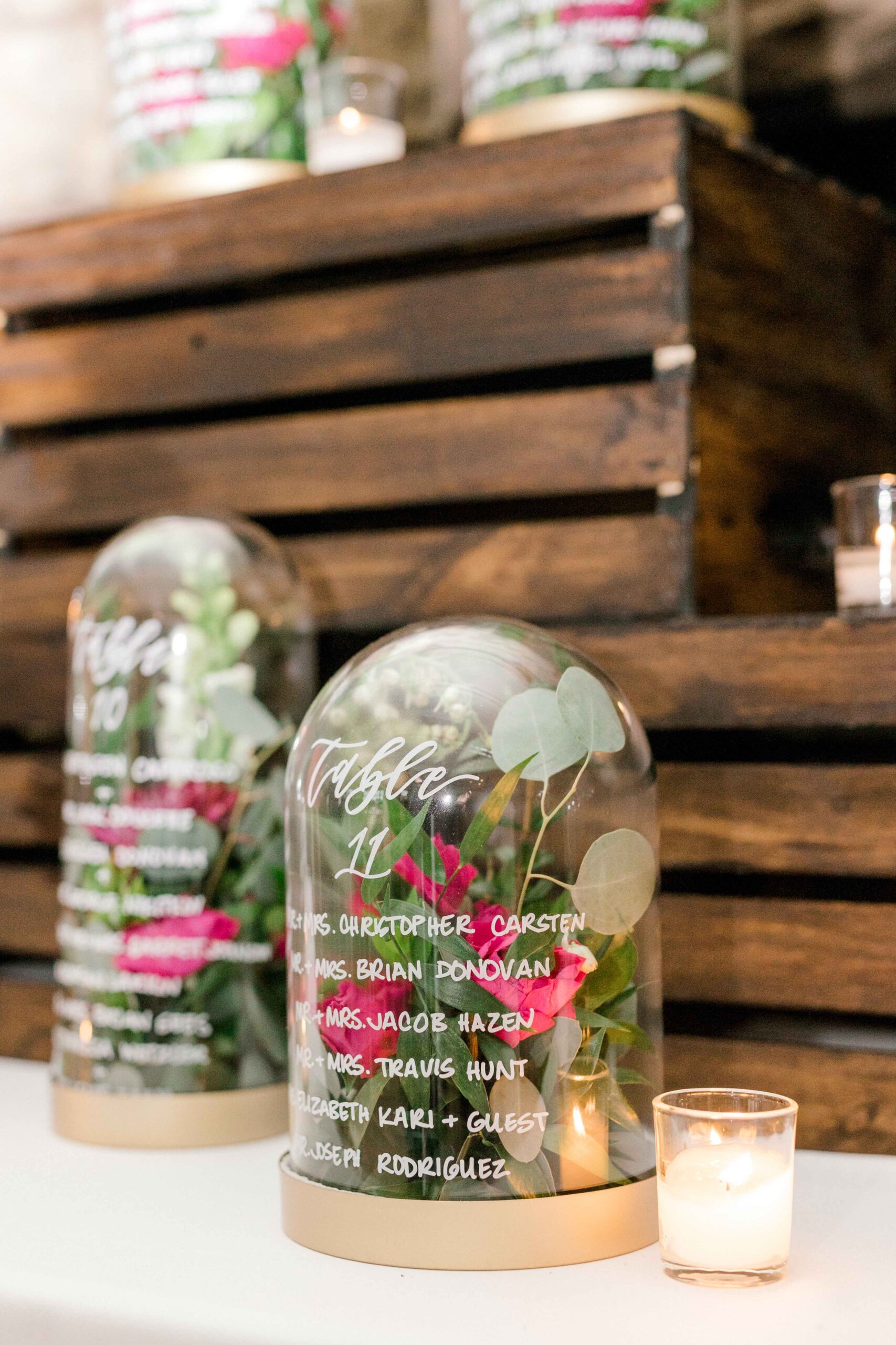 This floral-filled cloche seating chart is a unique wedding decor idea.