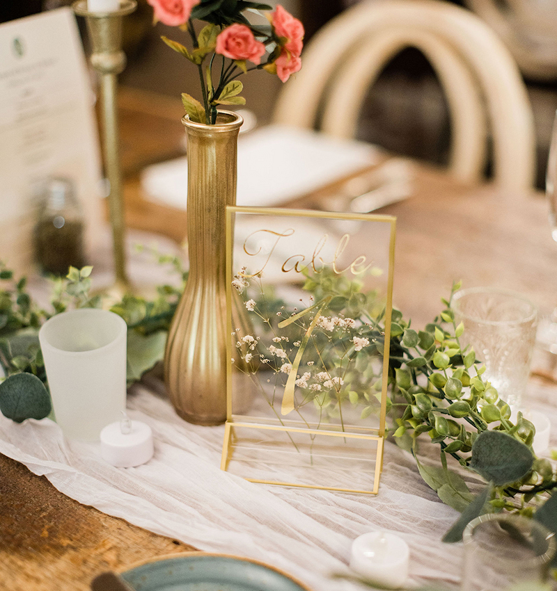 For their Waterloo Village wedding, the couple chose clear framed table numbers with flowers inside.