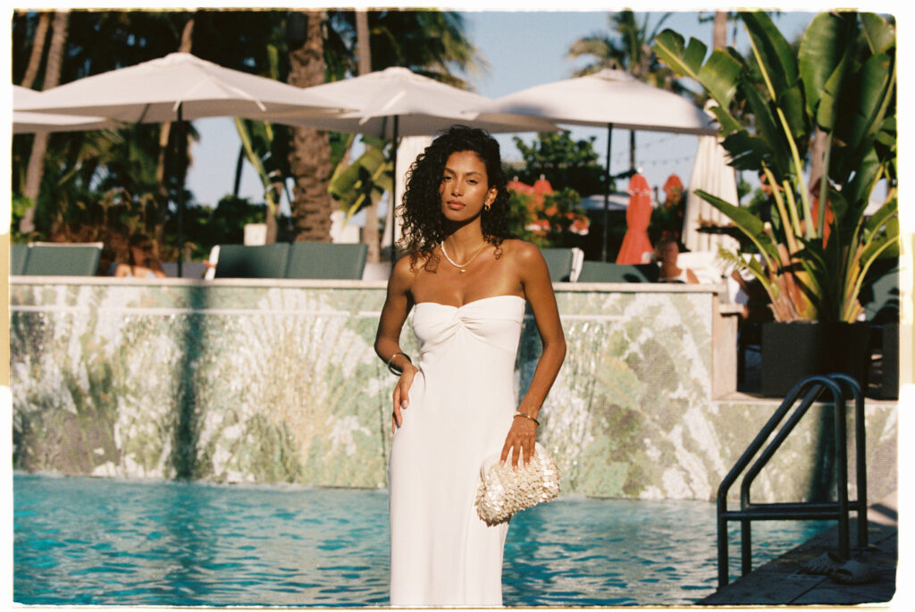 Cream honeymoon beach dress and shell-embellished clutch from LSPACE